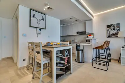 a kitchen with a table and chairs in a room at DAYF-SKG04 Modern Spacious 1 Bed Full DIFC Views in Dubai