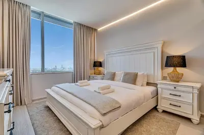 a white bedroom with a large bed and a window at DAYF-SKG04 Modern Spacious 1 Bed Full DIFC Views in Dubai