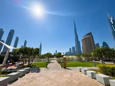 a park in a city with tall buildings at Chic 1BR in Downtown Dubai-Direct access to Dubai Mall in Dubai