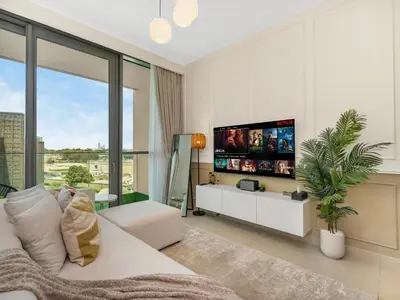 a living room with a white couch and a tv at Chic 1BR in Downtown Dubai-Direct access to Dubai Mall in Dubai