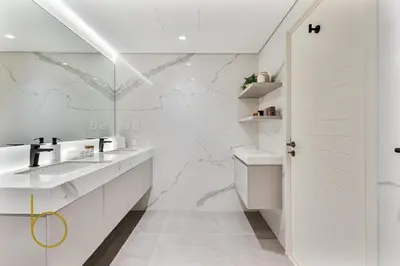 a bathroom with two sinks and a marble wall at Bookable - 2 Bedroom Boulevard Central in Dubai