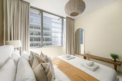 a bedroom with a bed with a large window at Silkhaus Cityscape 2BR in DIFC Prime location in Dubai