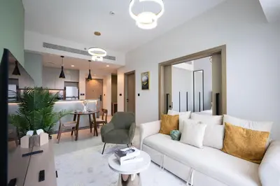 a living room with a white couch and a table at KeyRock Golf Gate - Stylish Retreat with Pool and Gym in Dubai