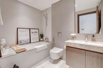 a white bathroom with a toilet and a sink at Beachfront Bliss 2Bedroom in Grand Bleu in Dubai
