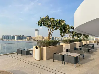 a row of tables and chairs on the roof of a building at Beachfront Bliss 2Bedroom in Grand Bleu in Dubai