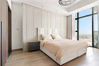 a bedroom with a large bed and a large window at Nobles tower tiger in Dubai