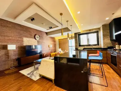 a kitchen and living room with a couch and a table at Upgraded High Rise 2 Br Full Marina Canal View in Dubai