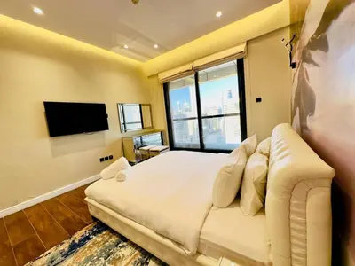 a bedroom with a large white bed and a flat screen tv at Upgraded High Rise 2 Br Full Marina Canal View in Dubai