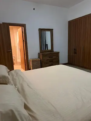 a bedroom with a bed and a dresser and a mirror at Stylish 1 bedroom apartment with full kitchen in Dubai