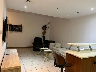 a living room with a couch and a guitar on the wall at Stylish 1 bedroom apartment with full kitchen in Dubai