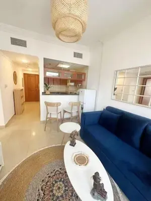 a living room with a blue couch and a table at Luxury 1 BHK in Dubai Marina By dPie Man 1011 in Dubai