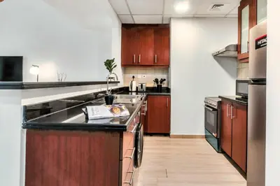 a kitchen with wooden cabinets and a counter top at Modern & Spacious Studio in JBR in Dubai