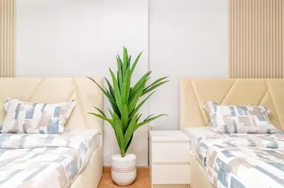 two beds in a room with a potted plant at Luxury 2BR in Dubai Marina Man 405 in Dubai