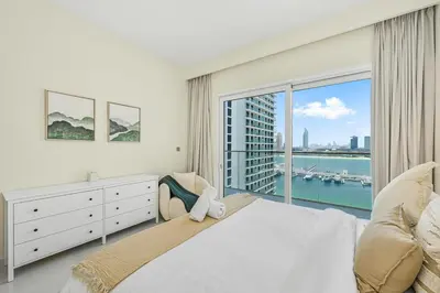 a bedroom with a large bed and a large window at Golden Stays - Luxury Emaar Beachfront 2BR I Sea & Palm Views in Dubai