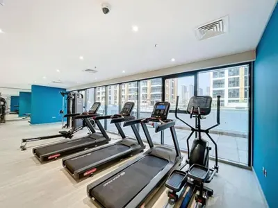 a gym with several treadmills and a large window at Azizi Riviera 18 - Peaceful Studio in Meydan in Dubai
