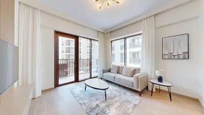 a living room with a couch and a table at Lotus Creek Beach - Opulent One Bed with Pool View in Dubai