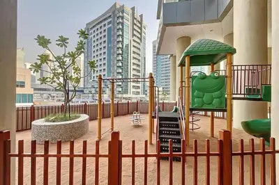 a playground in a building with a fence at Cozy and Spacious 2Bedroom with Marina Bay view in Dubai