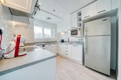a kitchen with white appliances and a white refrigerator at Cozy and Spacious 2Bedroom with Marina Bay view in Dubai