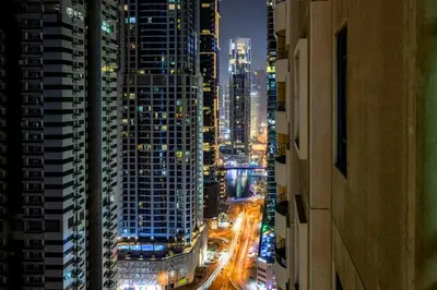 a view of a city at night with buildings at Elegant 2BR - Stunning Sea Views & Prime Location in Dubai