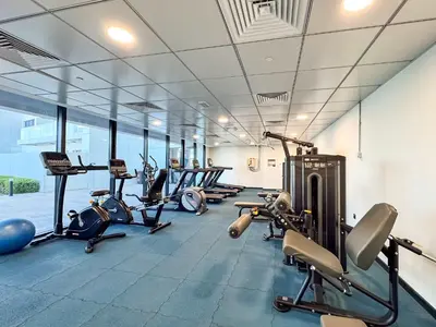 a gym with several treadmills and cardio machines at PVH - Modern 1BR Near Metro - Alexis Tower in Dubai