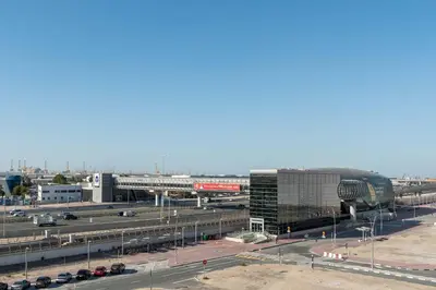 an airport with a parking lot and a building at PVH - Modern 1BR Near Metro - Alexis Tower in Dubai