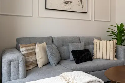 a living room with a gray couch with pillows at White Sage Newly Renovated 1BR Business Bay Hamilton Residency in Dubai