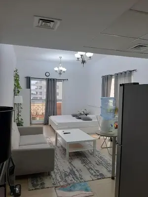a living room with a couch and a table at Studio with homely cozy and positive vibes in Sabkhah