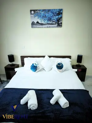 a bedroom with a bed with white sheets and blue eyes at Modern 1BR Apartment with Pool & Gym, 15 Min to JBR in Dubai