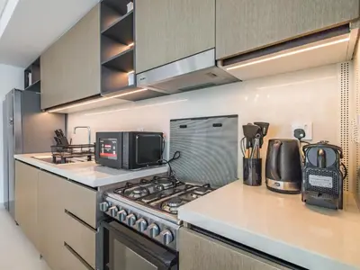 a kitchen with a stove and a microwave at The Norway Condo - 2BR Burj Khalifa View in Dubai