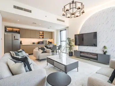 a living room with a couch and a tv at The Norway Condo - 2BR Burj Khalifa View in Dubai