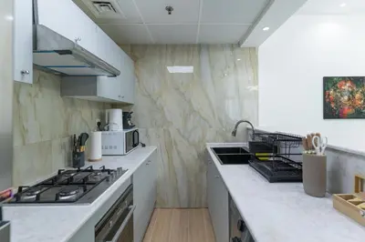 a kitchen with white counters and a stove top oven at Dubai Marina - 2BHK Luxurious Apartment in Dubai