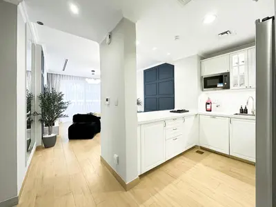 an open kitchen with white cabinets and a black door at Stylish 3BR Retreat Bright Interiors Townhouse Comfort in Dubai