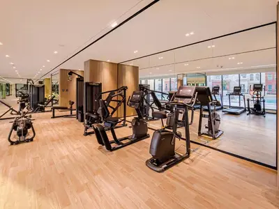 a gym with treadmills and exercise equipment in a building at A Signature Living Experience Luxury One-Bedroom in Binghatti Emerald, JVC, Dubai in Dubai
