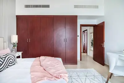 a bedroom with a bed and wooden cabinets and a sink at MiamiDXB Full Sea View -2Bd apartment in Dubai