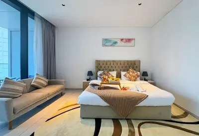 a bedroom with a bed and a couch at Spacious Studio Private Balcony Sea View in Dubai