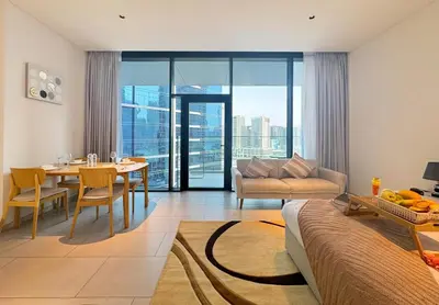 a living room with a table and a couch and a dining room at Spacious Studio Private Balcony Sea View in Dubai