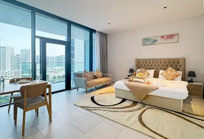 a bedroom with a king sized bed and a desk and a table at Spacious Studio Private Balcony Sea View in Dubai