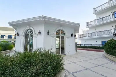 a white building with large windows and a courtyard at EasyGo- Luxury Living with Resort Facilities and Amenities in Dubai