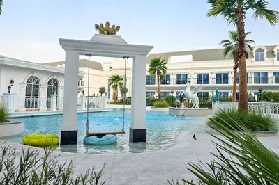 a swimming pool with a swing in front of a building at EasyGo- Luxury Living with Resort Facilities and Amenities in Dubai