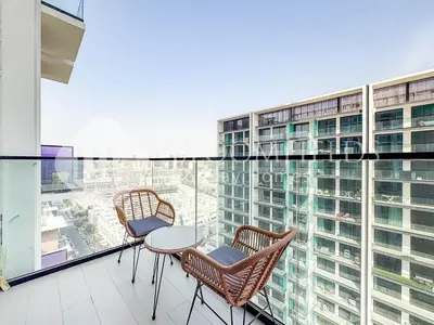 two chairs and a table on the balcony of a building at Bloomfields Cozy 1Br Binghatti House in Dubai