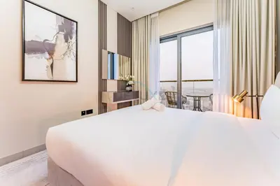 a bedroom with a large white bed and a window at High Floor, Few Steps From Dubai Canal and Waterfront Promenade, Sobha Hartland Waves, Sobha Hartland by Deluxe Holiday Homes in Dubai