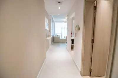 a hallway with white walls and a white floor at Canal-View one bedroom Apt Business Bay in Dubai