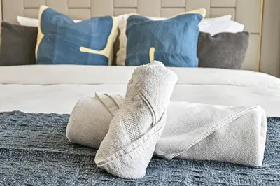 a towel on the floor in a bedroom with a bed at Golden Stays - 5 Mins From Mall I Downtown Dream 1Br Apt in Dubai