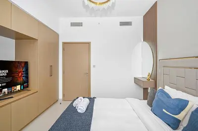 a bedroom with a large bed with a tv on it at Golden Stays - 5 Mins From Mall I Downtown Dream 1Br Apt in Dubai