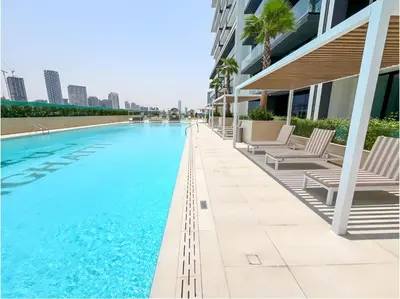 a swimming pool with chaise lounge chairs next to a building at Solysian Stay in Dubai