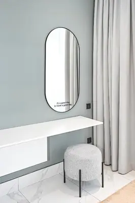 a dressing table with a mirror and a stool at Stylish Apartment with Balcony and Pool, Close to Dubai's Top Landmarks in Dubai