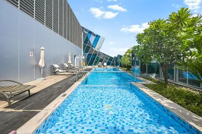 a swimming pool in front of a building at Stylish Apartment with Balcony and Pool, Close to Dubai's Top Landmarks in Dubai