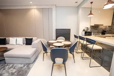 a living room with a couch and a table and chairs at Highlife Haven in Dubai with Pool and Gym in Dubai