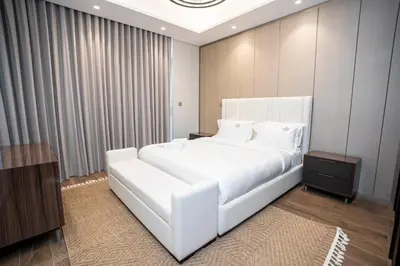 a bedroom with a large white bed and a table at Highlife Haven in Dubai with Pool and Gym in Dubai