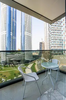 a balcony with a table and chairs and buildings at Luxe 1BR Suite Dubai Dream Stay with Pool and Gym in Dubai
